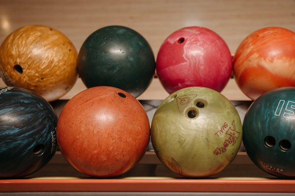 Colourful balls lined up on a rack, much like the polyester Ebonite bowling balls such as the Maxim