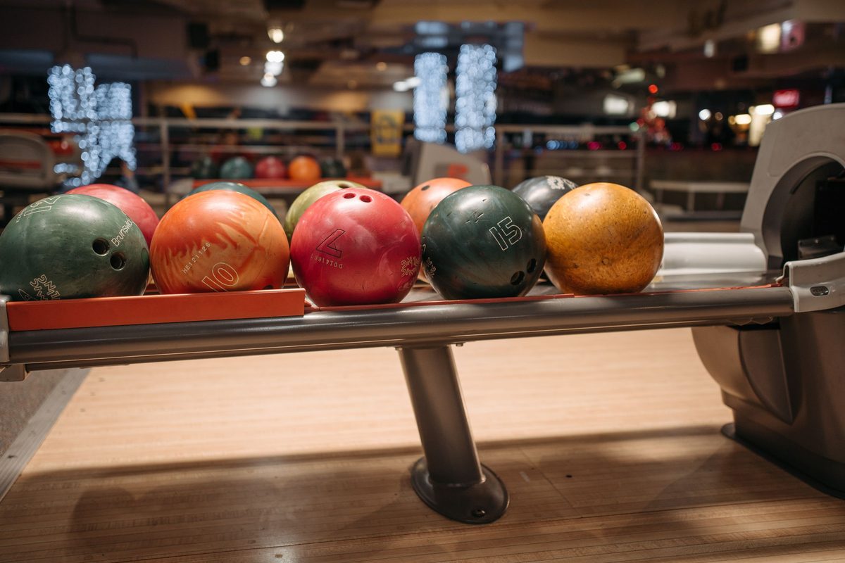Colourful house balls waiting on the ball return, as found at bowling alleys in Perak