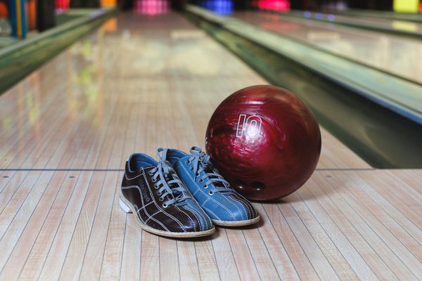 A pair of bowling shoes and a ball on the lane, the kind of bowling shoes sold and rented in Malaysia